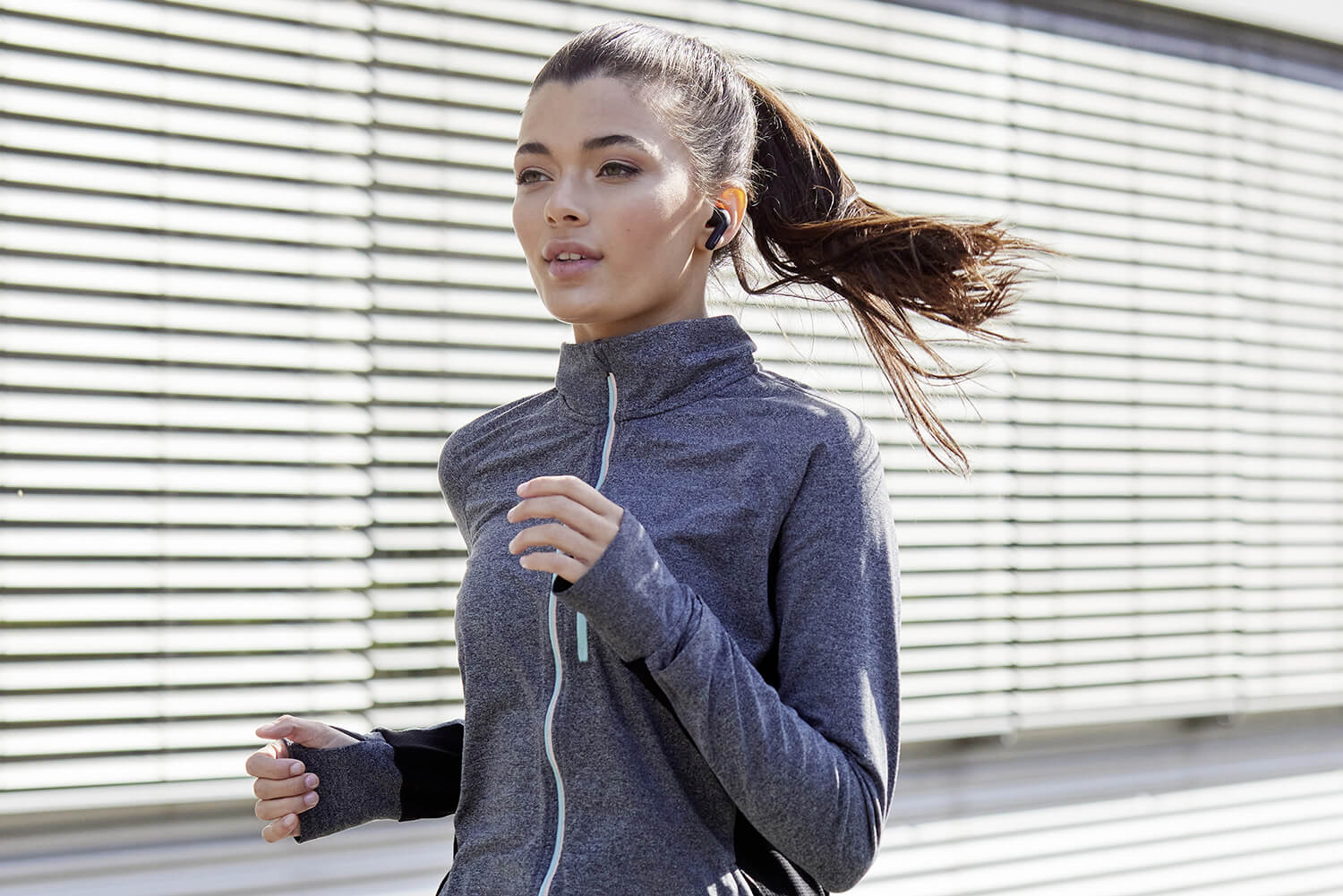 Eine Frau beitreibt Laufsport mit den Intenso Buds.